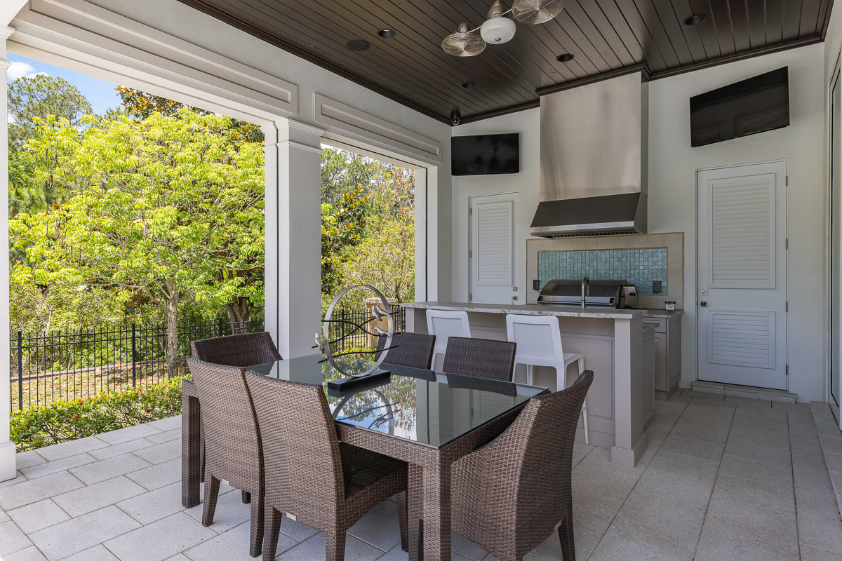 outdoor kitchen with island and table with chairs